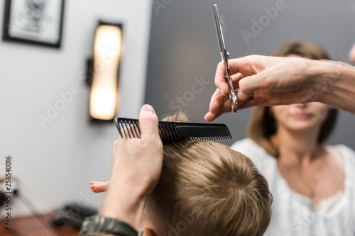 Barber cutting a little boy close-up