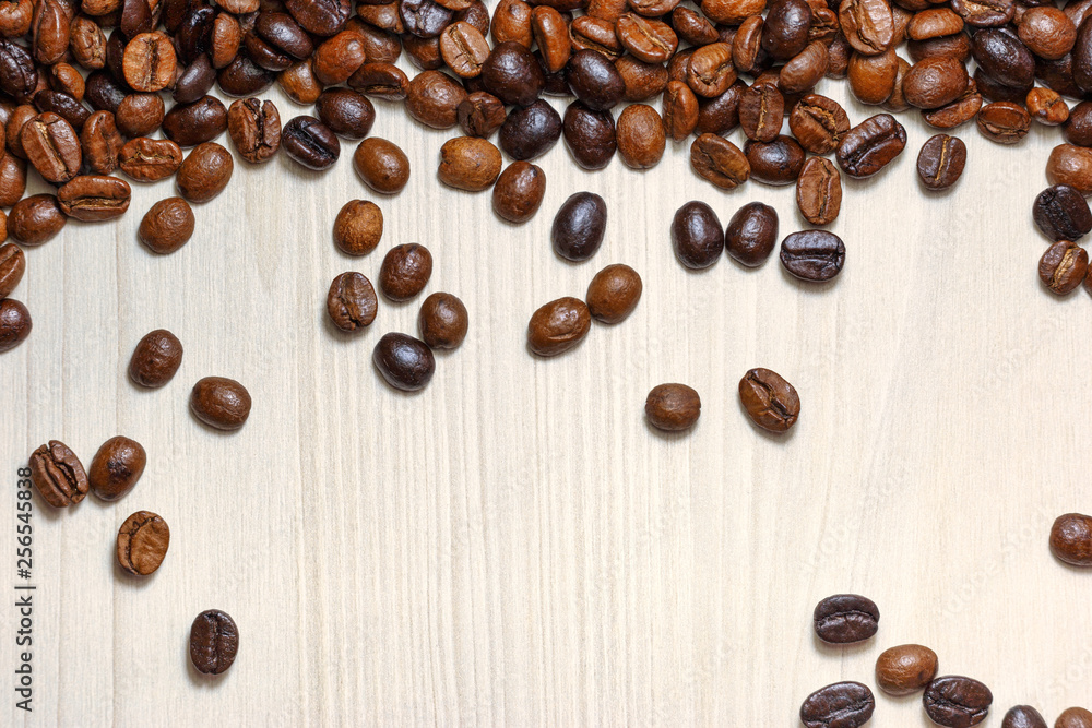 Coffee beans on a light wooden table Coffee beans on a light wooden table