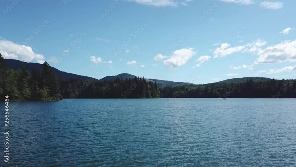 A breathtaking aerial shot of a lake with beautiful blue skies and forest filled shorelines. A breathtaking aerial shot of a lake with beautiful blue skies and forest filled shorelines.