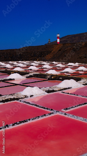 24 November 2018 La Palma Canary Islands, Salinas Marinas de Fuencaliente, Salts Flats and Mine showing multi coloured salt water fields aganst blue sky and waves photo