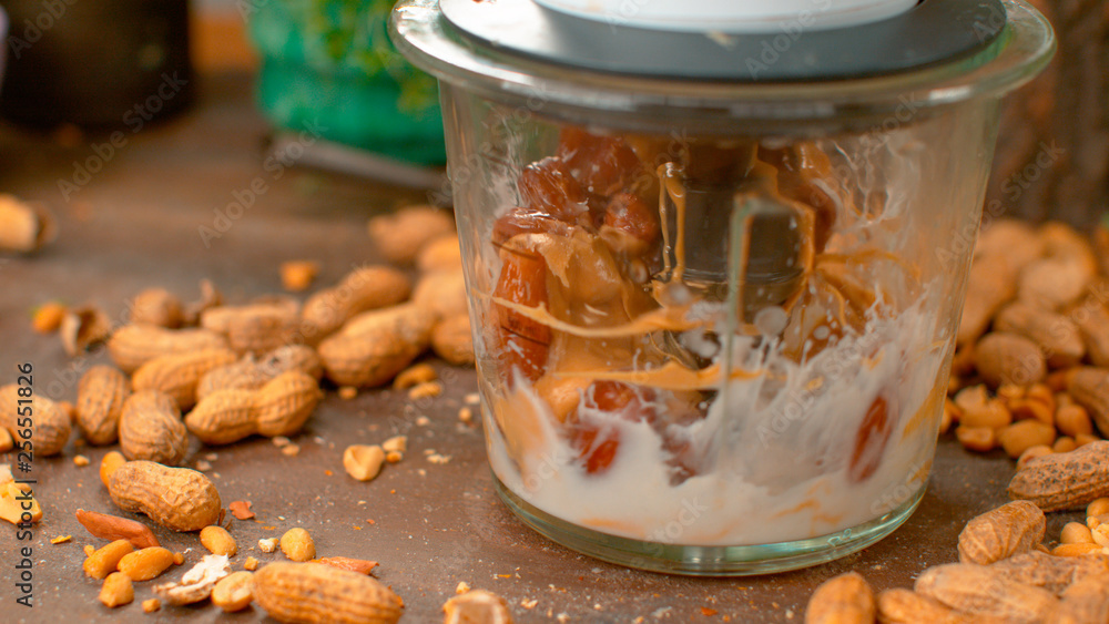 MACRO: Kitchen blender mixes salty peanut butter with milk and sweet dried dates MACRO: Kitchen blender mixes salty peanut butter with milk and sweet dried dates