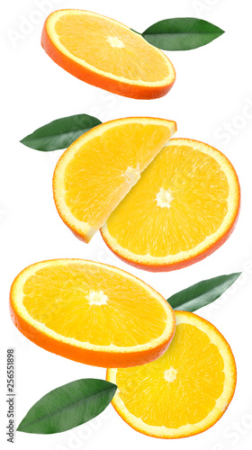 Flying juicy orange slices and citrus leaves on white background
