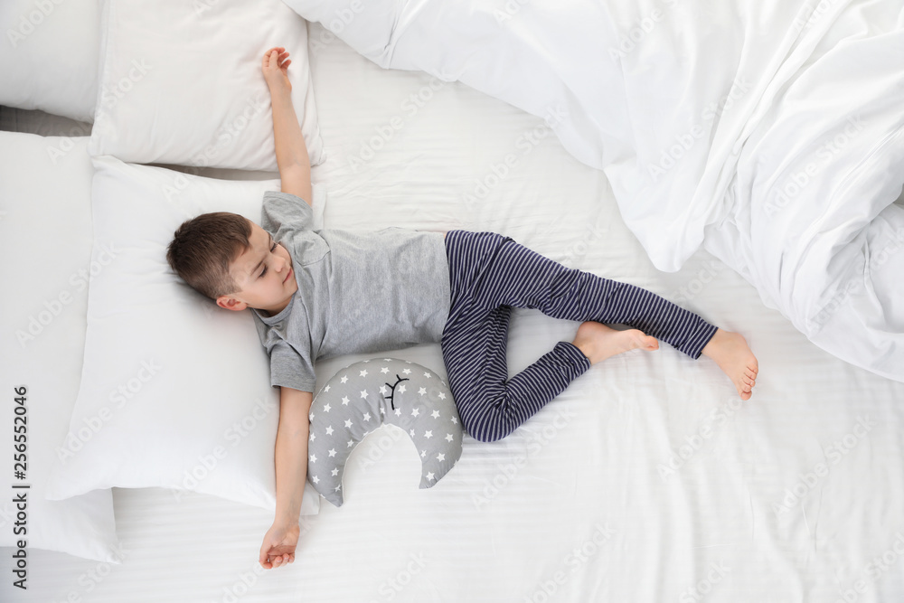 Cute little boy with toy sleeping on bed, above view - obrazy, fototapety, plakaty 