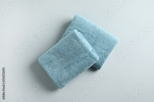 Fresh fluffy folded towels on grey background, top view. Mockup for design