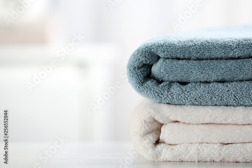 Stack of fresh towels on table, closeup. Space for text