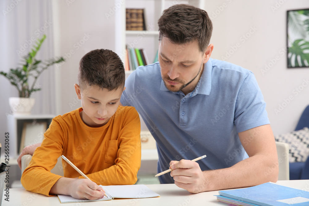 Dad helping his son with homework in room Dad helping his son with homework in room