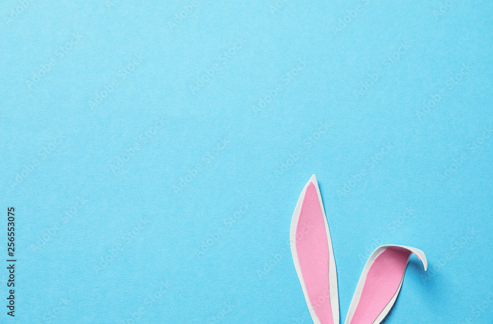 Funny Easter bunny ears on color background, top view with space for text