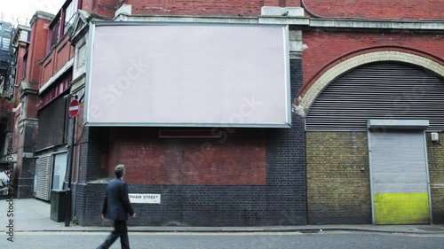 Businessman walking past blank billboard