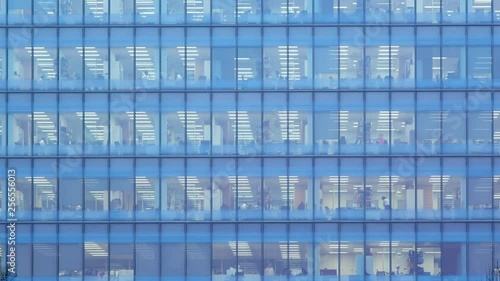 Day to night Timelapse of the exterior of an office block at night revealing the daily activity of office workers night themes of routines working late deadlines