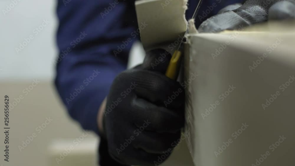 Closeup of a young man in a furniture factory who cut the excess parts of the sofa Closeup of a young man in a furniture factory who cut the excess parts of the sofa