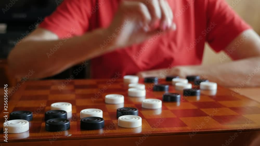 Aged couple playing checkers in Go game on the chessboard at home, close up Aged couple playing checkers in Go game on the chessboard at home, close up
