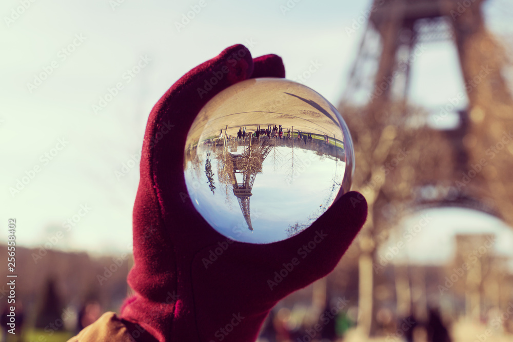 Female hand holding lensball with refraction of the Eiffel Tower in ...