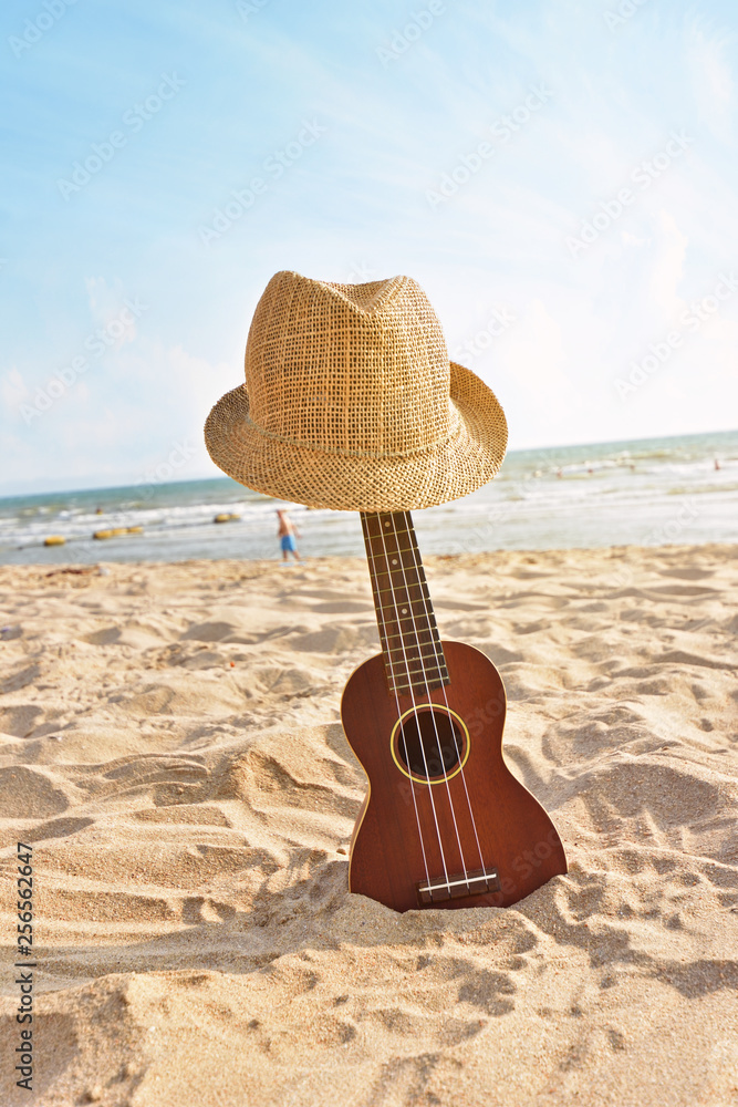 The Summer day with Guitar ukulele for on the beautiful beach and blue background Photo | Adobe Stock