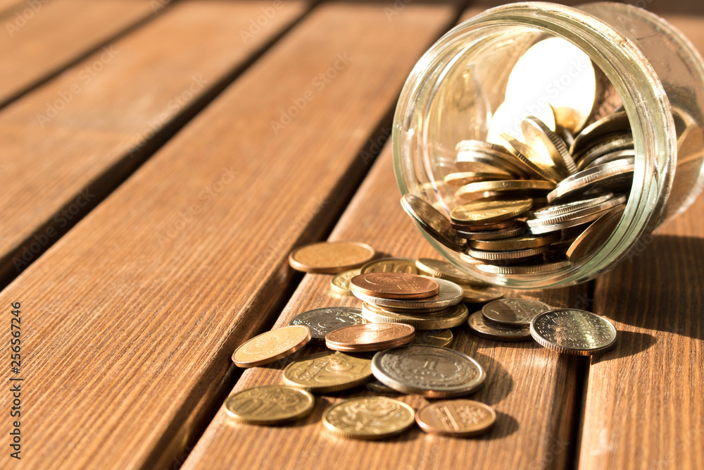 Various coins are scattered on a wooden table. The concept of poverty Various coins are scattered on a wooden table. The concept of poverty