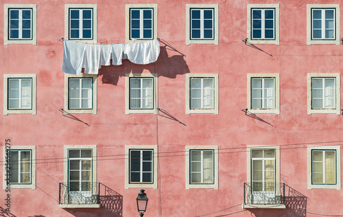 Pink facade of european house with simmetrical windows 