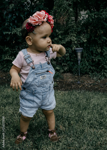 little girl in the park biting her finger photo