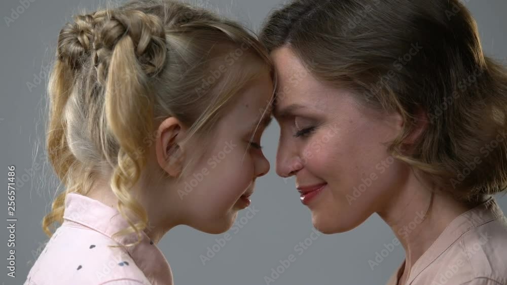 Mom and daughter leaning heads, trusting relations with parents, reliance