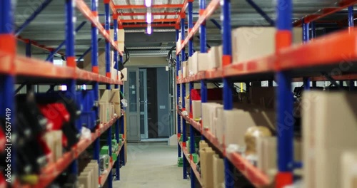 View of the interior inside industrial warehouse. Variety of spare parts boxes on shelves and tires on the floor. photo