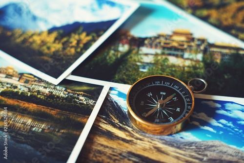Compass on blur photograph of popular tourist destination background, traveling destination plan concept