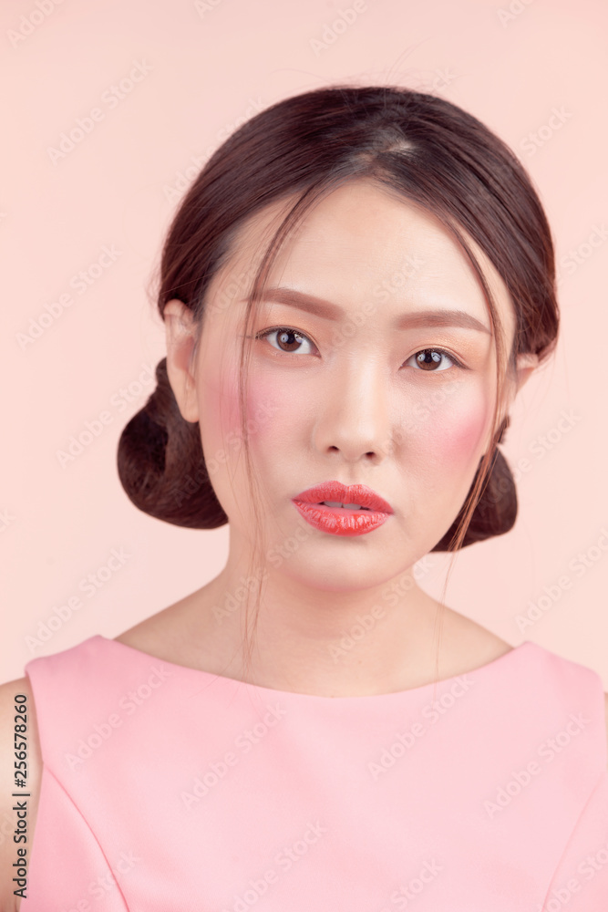 Fashion portrait of a beautiful young woman in a pretty dress over pink background Fashion portrait of a beautiful young woman in a pretty dress over pink background
