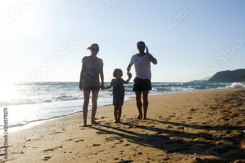 Happy family enjoying on beach. Summer vacation, family with one child having fun on beach