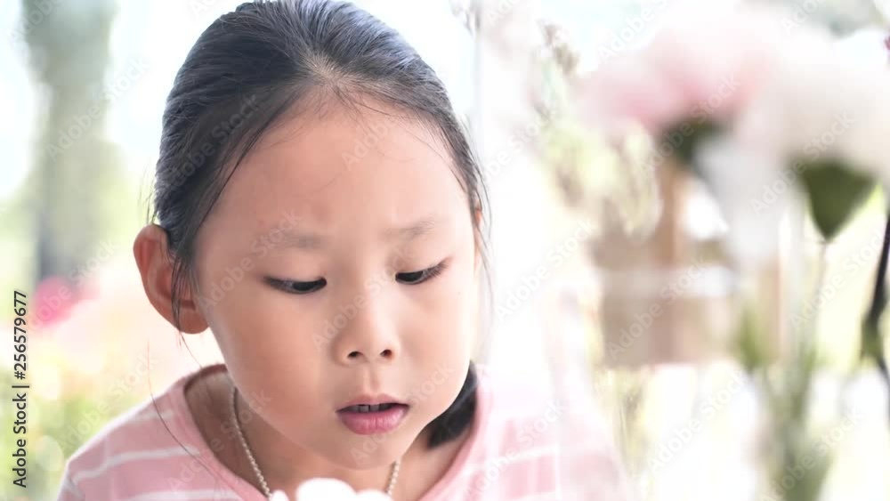 Asian girl eating fried sausage near window at home, lifestyle concept. Slow motion shot. Asian girl eating fried sausage near window at home, lifestyle concept. Slow motion shot.