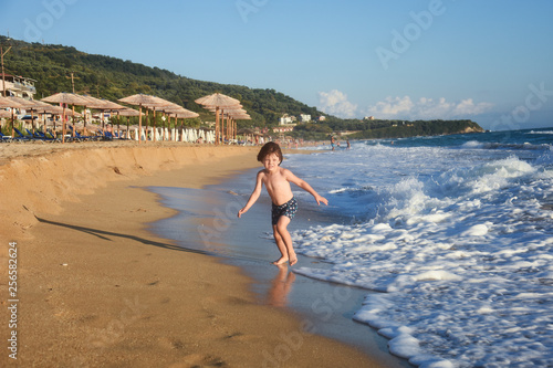 Child running and play at beach. Little boy play by the sea on summer vacation © Ivan