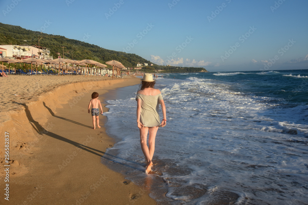 Mother and son playing on the sandy beach. Summer vacation concept, mom and little boy enjoy at beach