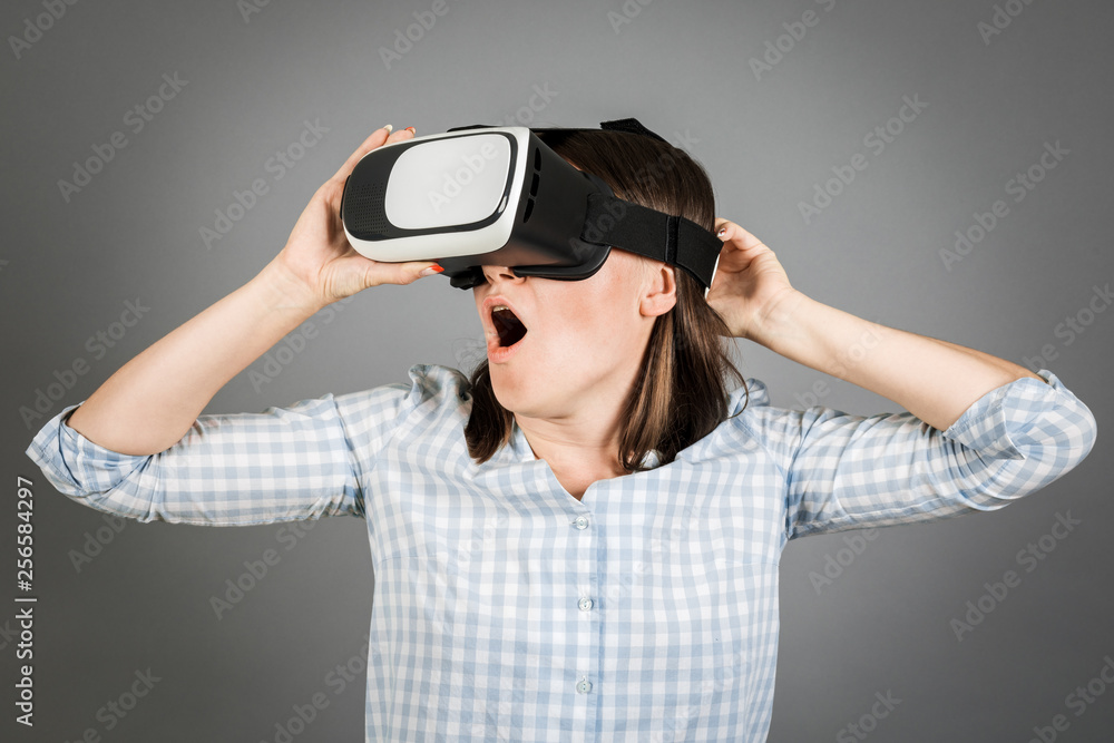 Woman with glasses of virtual reality. Future technology concept. On a gray background. Woman with glasses of virtual reality. Future technology concept. On a gray background.