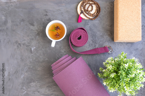Rolled yoga mat with mala beads and Ayurveda tea for relax yoga practice y meditation.