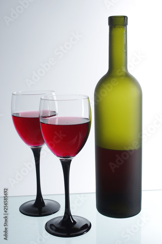 Wine in bottles and in glasses on a white background.