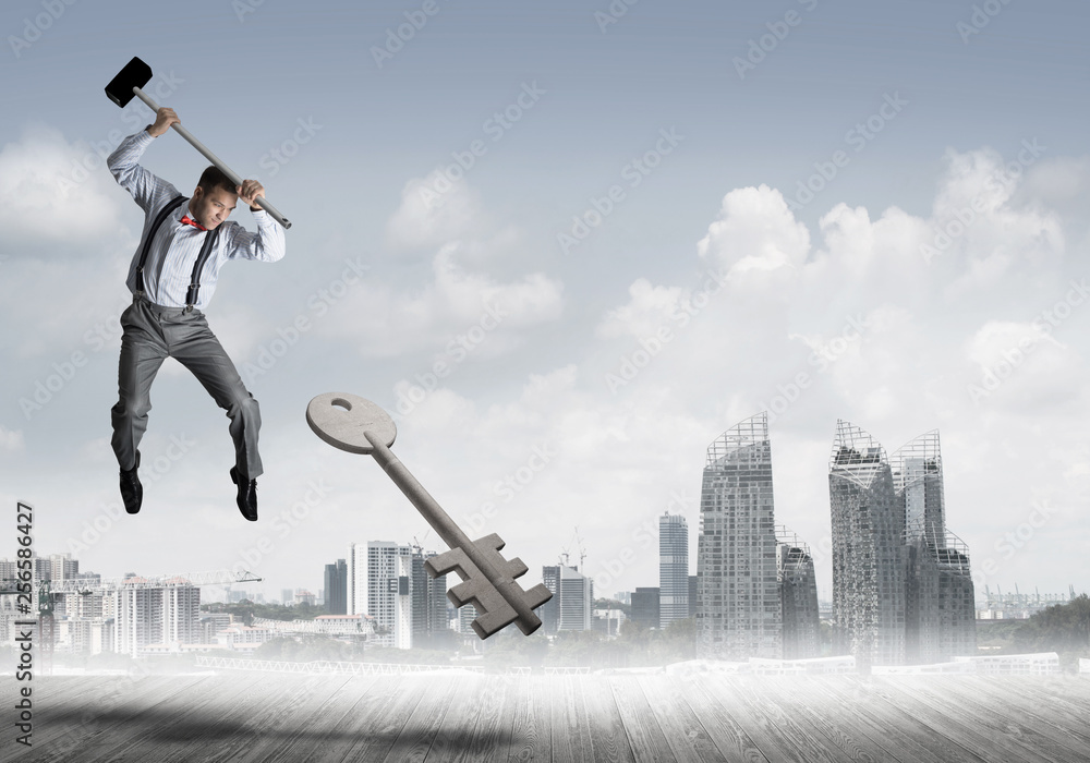 Breaking through access concept with man in anger crashing concrete key Breaking through access concept with man in anger crashing concrete key
