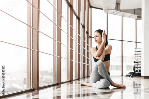 Young slim attractive woman with long hair practicing yoga indoors. © bedya