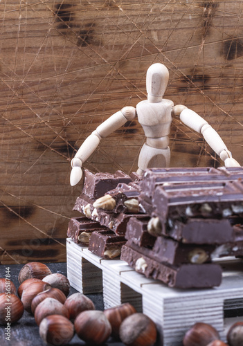 Czekolada ukladana na paletacie przez drenianego ludzika, lalke, magazyn czekolady.