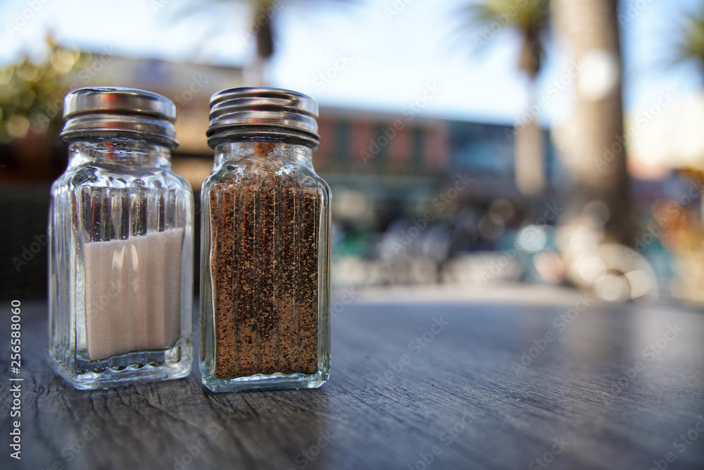 Salt and pepper shaker on a wood table Salt and pepper shaker on a wood table