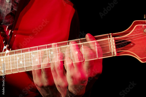 The dynamics of playing the guitar. Guitarist fingers spread all over the fretboard. Repeated exposure.