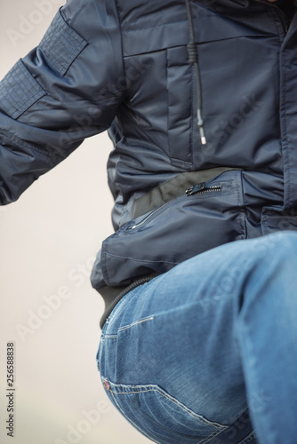 A man posing in a black winter jacket and jeans. Advertise menswear