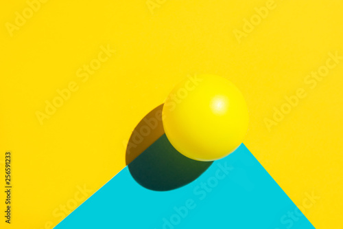 Fototapeta Yellow tennis ball on duotone blue polygon shape element