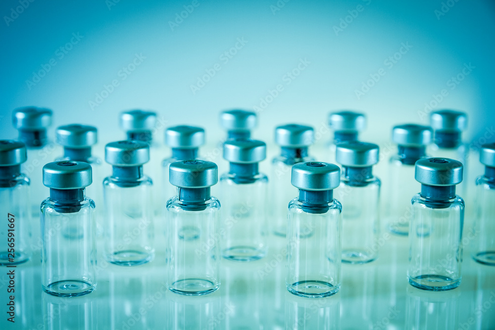 Vaccine glass bottles on blue background