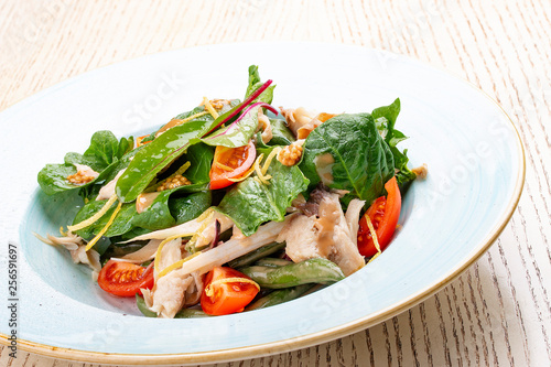 Mix salad with chicken and tomatoes. On light background