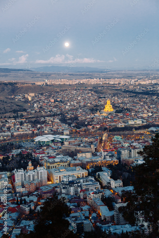 Obraz premium Sunset and evening city Tbilisi, Georgia. Panoramic views and lights of historic neighborhoods.