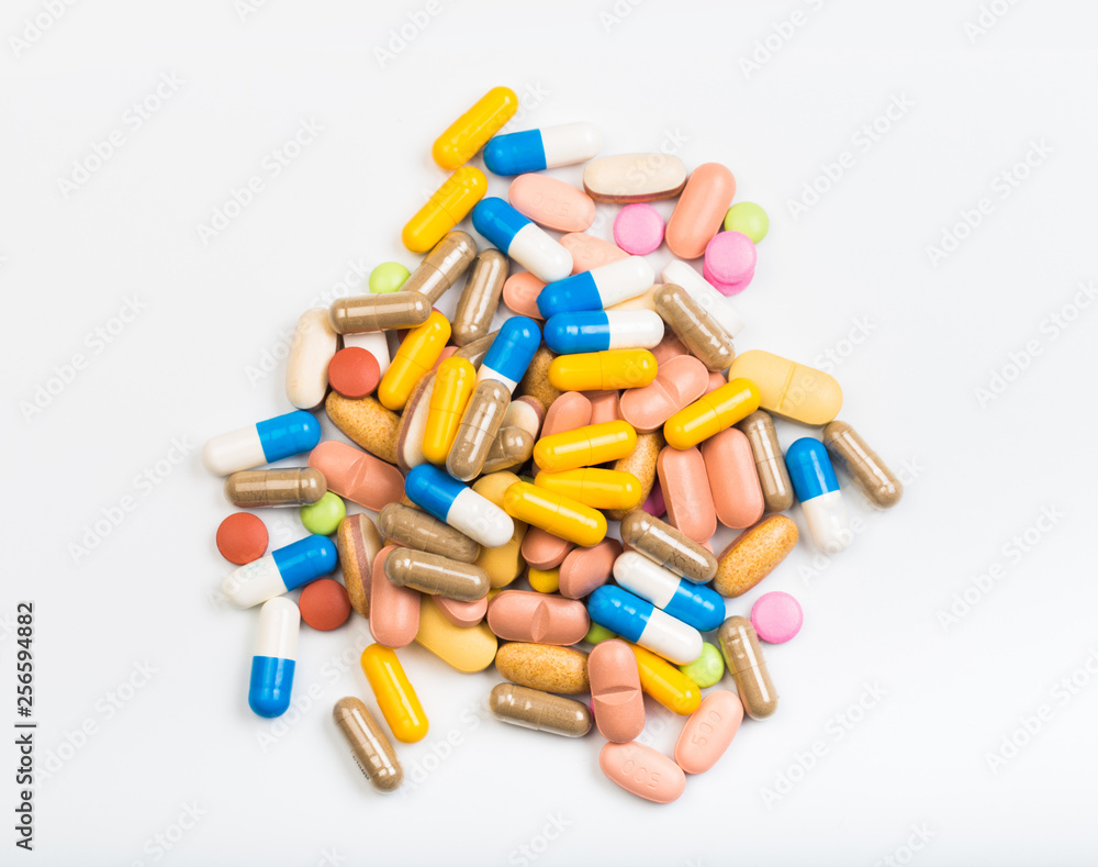 set of multi-colored tablets and capsules on a white background set of multi-colored tablets and capsules on a white background