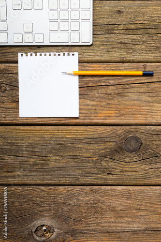 place of work, white note paper, pencil, keypad, old wooden table background