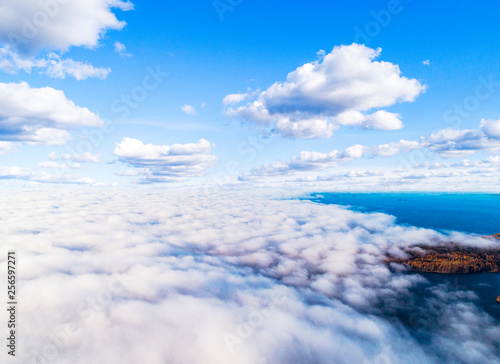 Aerial view over forest during vibrant autumn colors. Aerial view of seashore and clouds. Coastline with sand and water. Aerial drone view of forest. Aerial top view cloudscape. Texture of clouds.