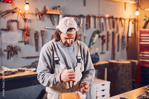Male carpenter fixing old wood in a retro vintage workshop.