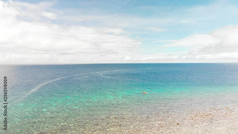 drone flying over fishing pump boat in a tropical open bright blue ocean under fluffy white clouds and blue sky drone flying over fishing pump boat in a tropical open bright blue ocean under fluffy white clouds and blue sky