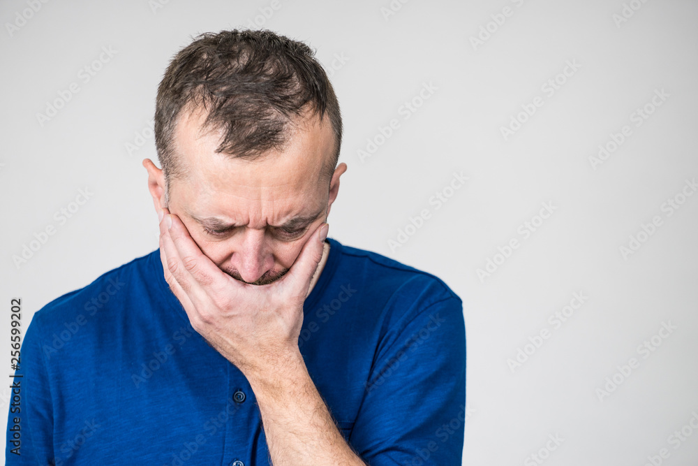 Sad worried man covering his mouth