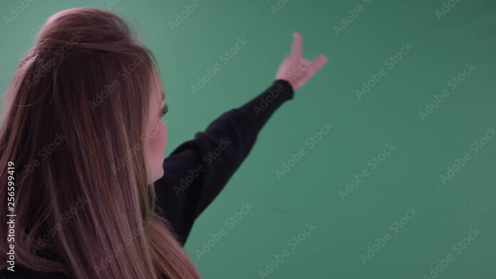 beautiful happy young thoughtful woman in black casual clothes is having selfies on her cellphone standing in close up in front of on green screen beautiful happy young thoughtful woman in black casual clothes is having selfies on her cellphone standing in close up in front of on green screen