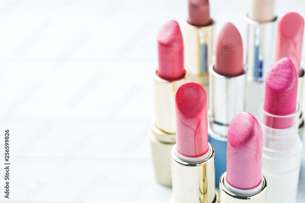 Set of colored pink lipsticks on white background. Women's cosmetics. Selective focus. Copy space. Set of colored pink lipsticks on white background. Women's cosmetics. Selective focus. Copy space.