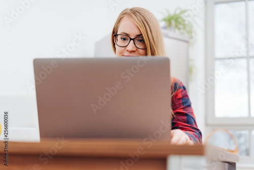 Young woman smiling while working on laptop © contrastwerkstatt